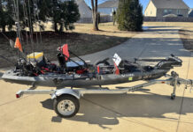 Fishing kayak with modifications in driveway.