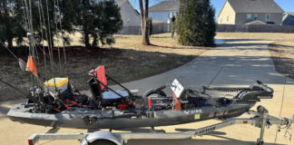 Fishing kayak with modifications in driveway.