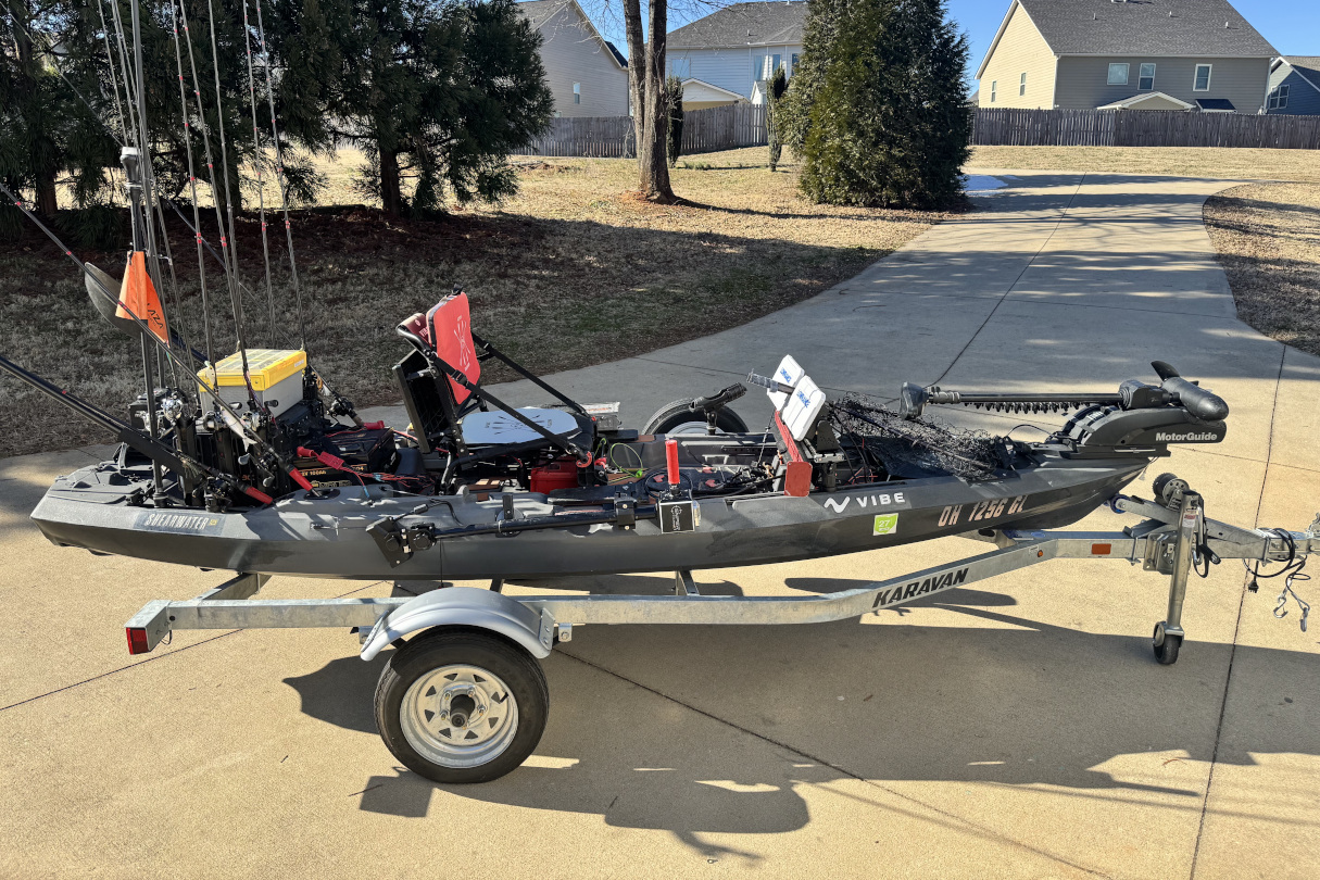 Fishing kayak with modifications in driveway.