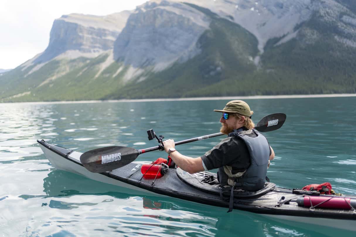 Man in a kayak on a scenic waterway.