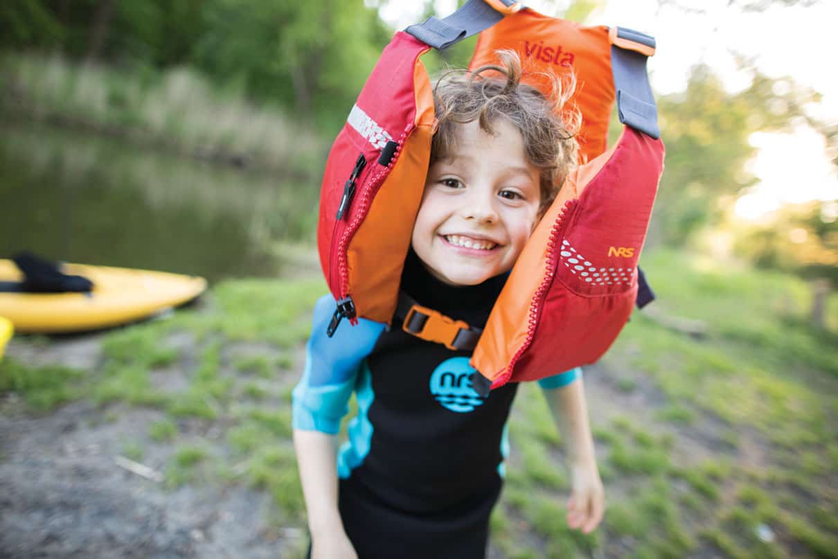 young person poses with an NRS Youth Vista life jacket