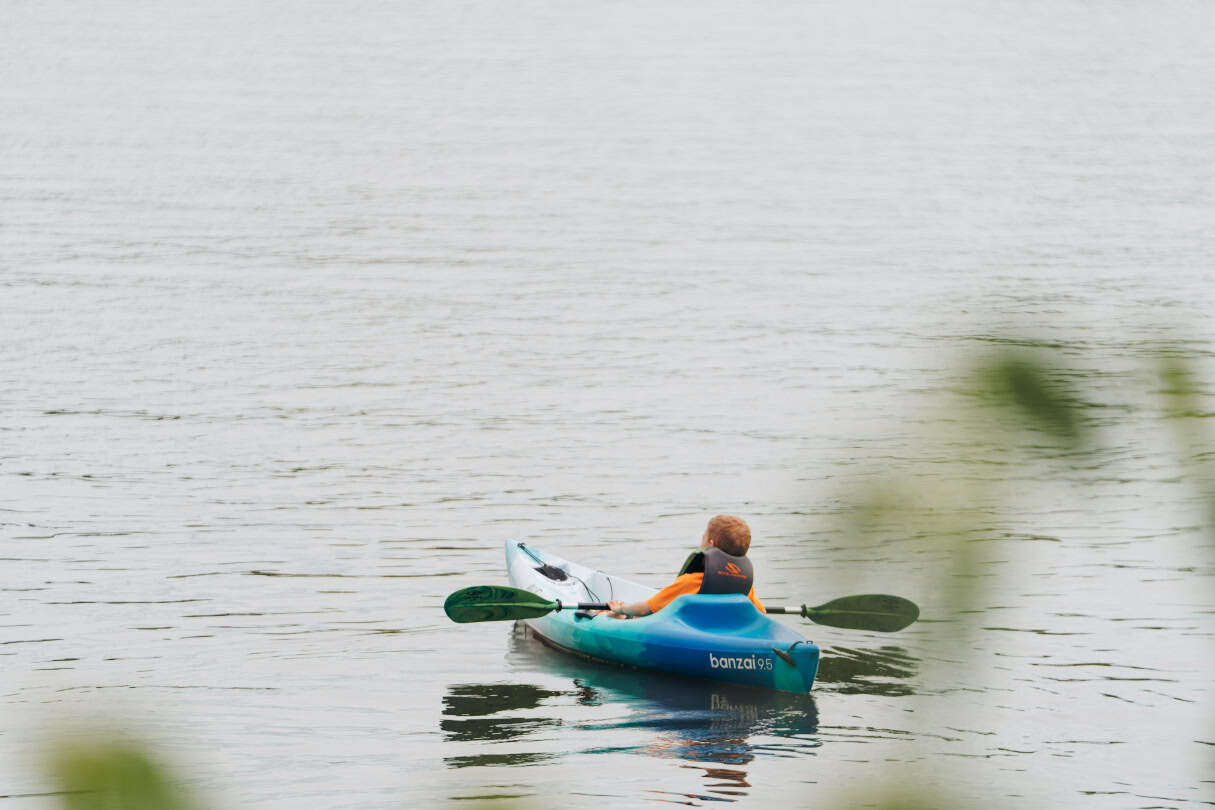 Kid in kayak on lake.