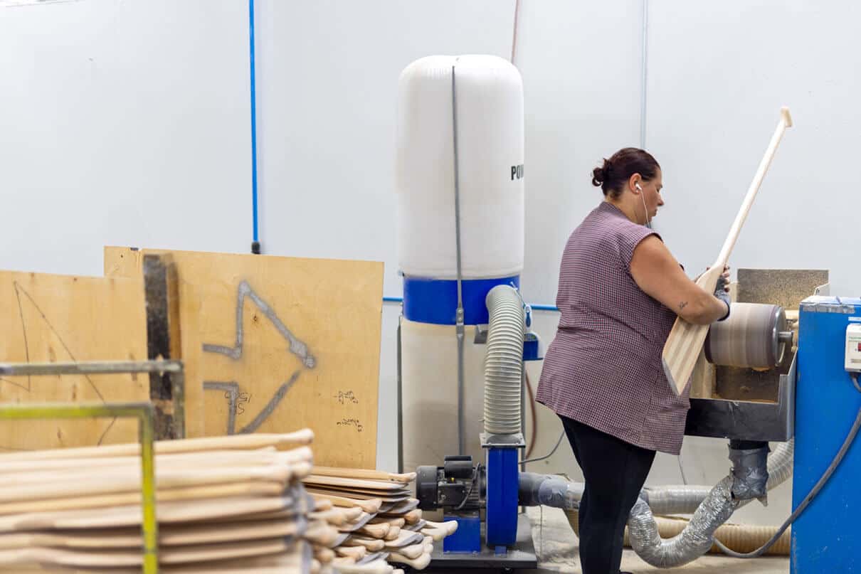 woman operates machinery in the Grey Owl Paddles factory