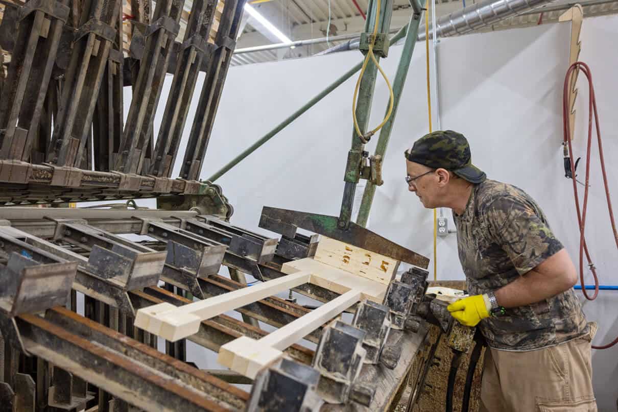 man operates machinery to carve Grey Owl paddles at their factory
