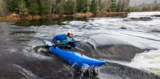 man paddles the Dagger Indra whitewater kayak in a rapid