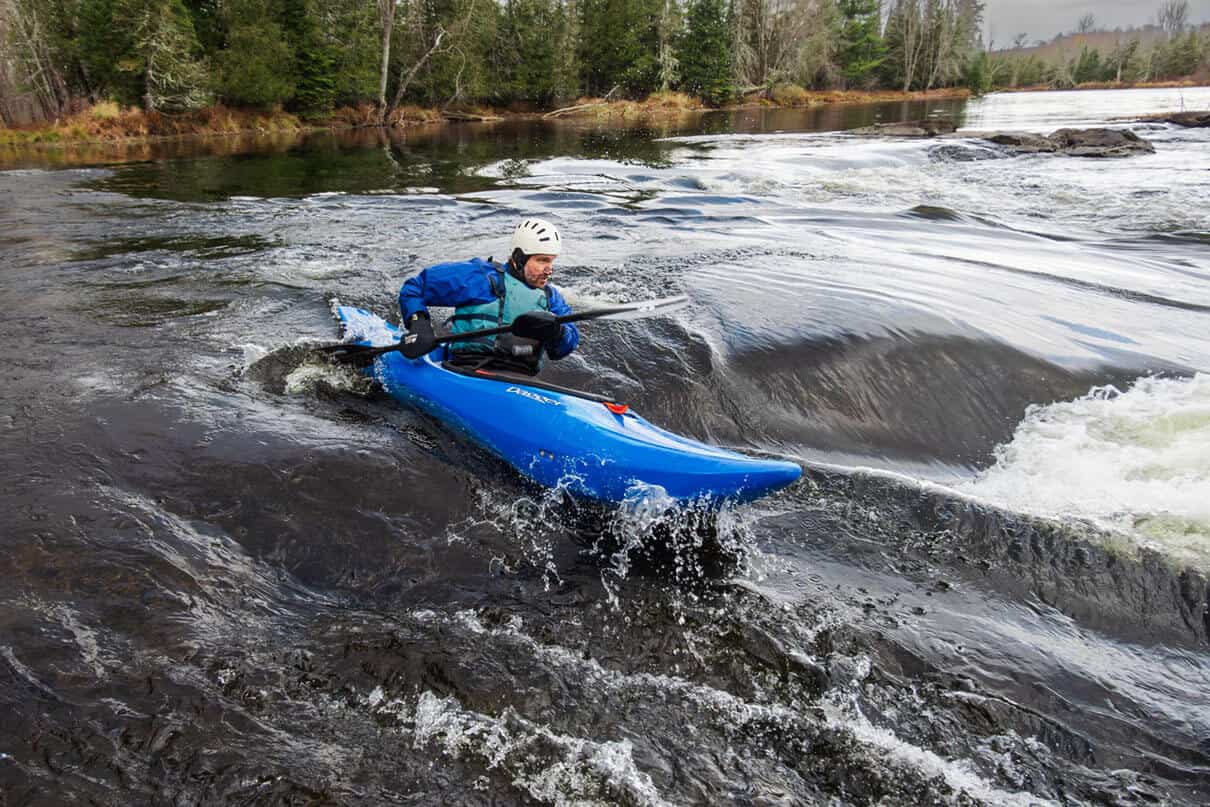 man paddles the Dagger Indra whitewater kayak in a rapid