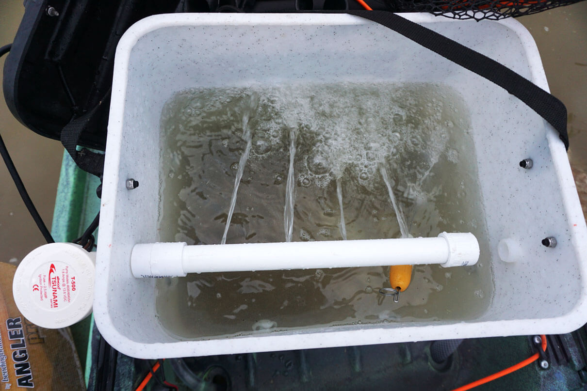 looking into the top of an open DIY kayak livewell with spray bar