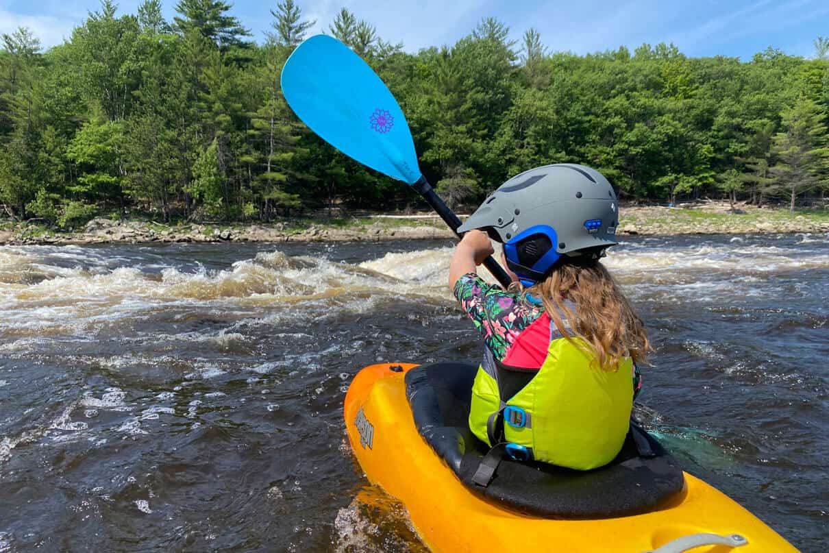 Tove in kayak holding paddle on the water