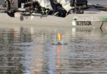 kayak angler casts a popping cork and it hits the water