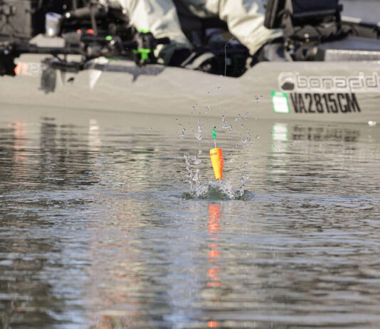 kayak angler casts a popping cork and it hits the water