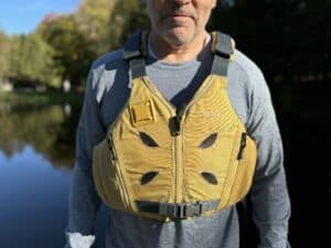man wearing astral ev-eight PFD by the water