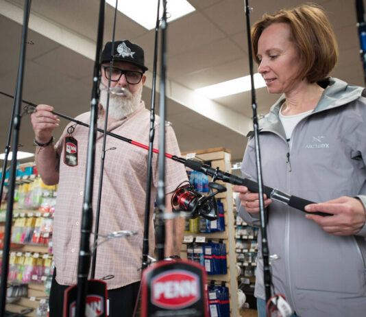 a local tackle shop manager helps a beginner kayak angler to get a good bargain on her purchases