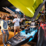 Beginners Guide To Kayak Fishing: Boats & Gear woman chats with a salesperson at the kayak shop about getting outfitted a beginner for kayak fishing