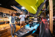 woman chats with a salesperson at the kayak shop about getting outfitted a beginner for kayak fishing