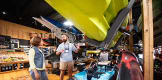 woman chats with a salesperson at the kayak shop about getting outfitted a beginner for kayak fishing
