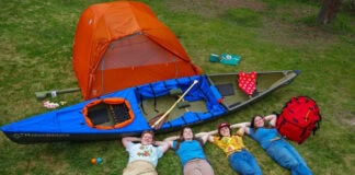 What’s Inside The Hudson Bay Girls’ Expedition Kit four members of the Hudson Bay Girls canoe expedition pose on a lawn with their gear for the trip