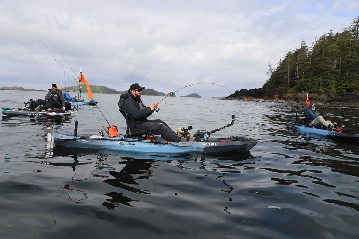 a group of kayak anglers fish on the water