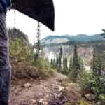 A New Generation Is Shaping The Future Of The Nahanni River a person portages a canoe near Virginia Falls on the Nahanni River