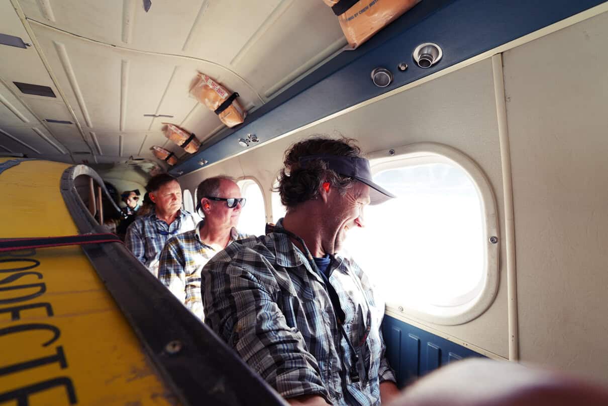 people sit in a small airplane cabin while it flies to Canada's north