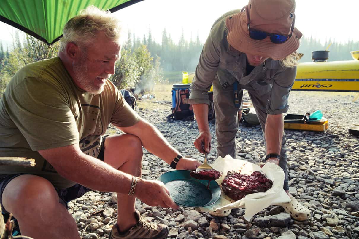 A guide shares food cooked at the canoe trip campsite