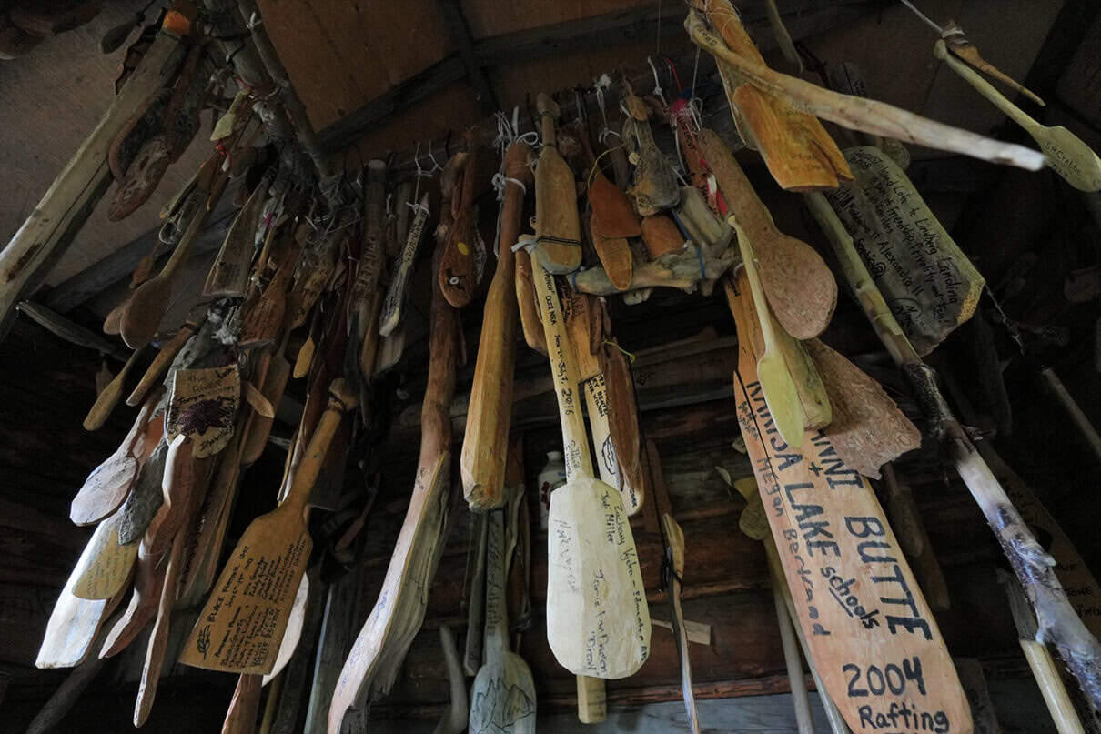 signed wooden paddles hang from the ceiling of the Paddle Cabin