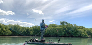 Sanibel Island, Florida: The Perfect Mix Of Peace And Fishing Adventure man stands and fishes from a kayak at Sanibel Island, Florida