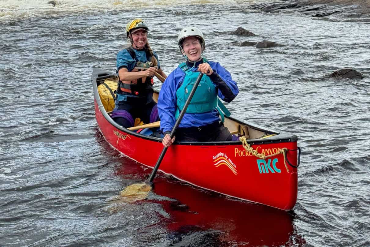 Two canoeists celebrating a whitewater run.