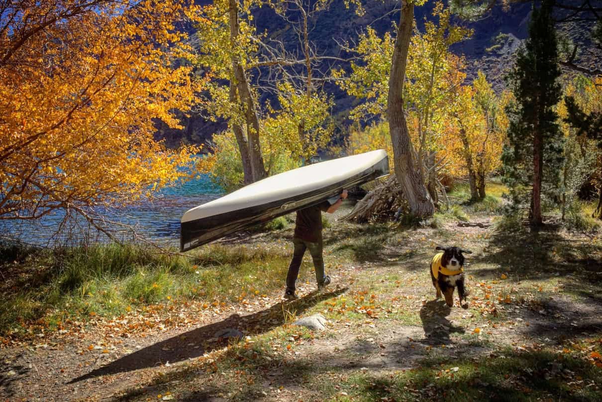 Person carrying a Swift Keewaydin canoe.