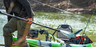 Essential Gear For Beginner Anglers beginner angler pulls his fishing kayak onto shore with gear