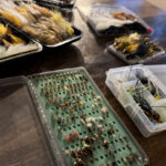 Six Tips To Build A Beginner Fly Box a selection of beginner fly fishing flies in a tackle box on a table