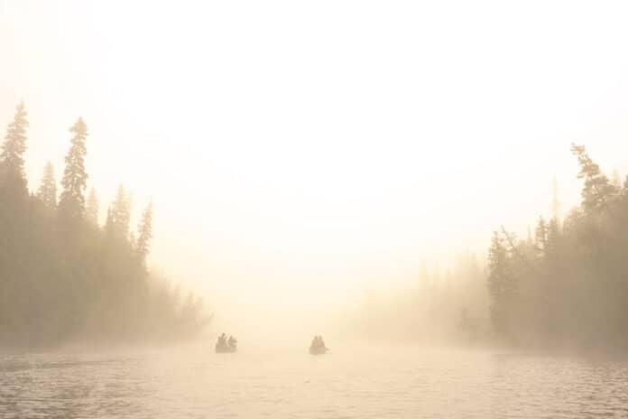 two canoes on a river on a misty day