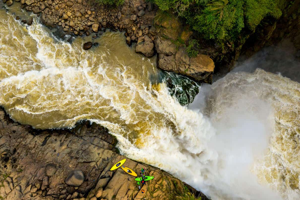 The expedition team standing on the lip of a 30-meter waterfall