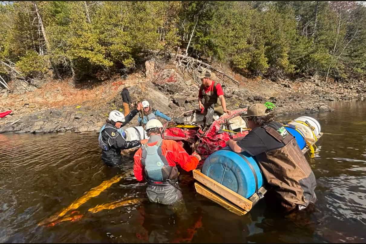 Image of kayakers rigging a sunken stolen car to remove it from the Ottawa River.