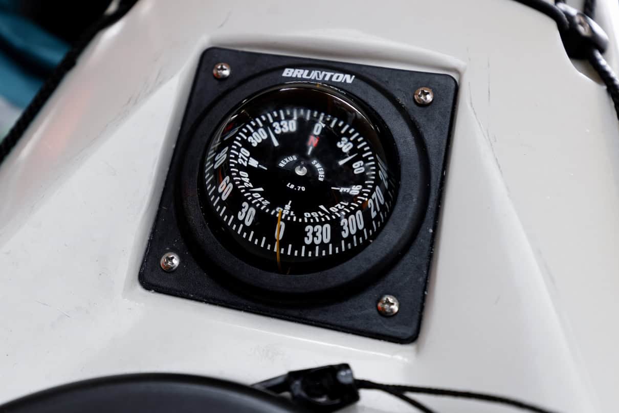 A kayak compass permanently mounted to the deck of the boat.
