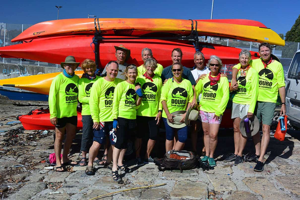 a group of Douro Kayak Expedition participants stand in front of kayaks lashed to a trailer