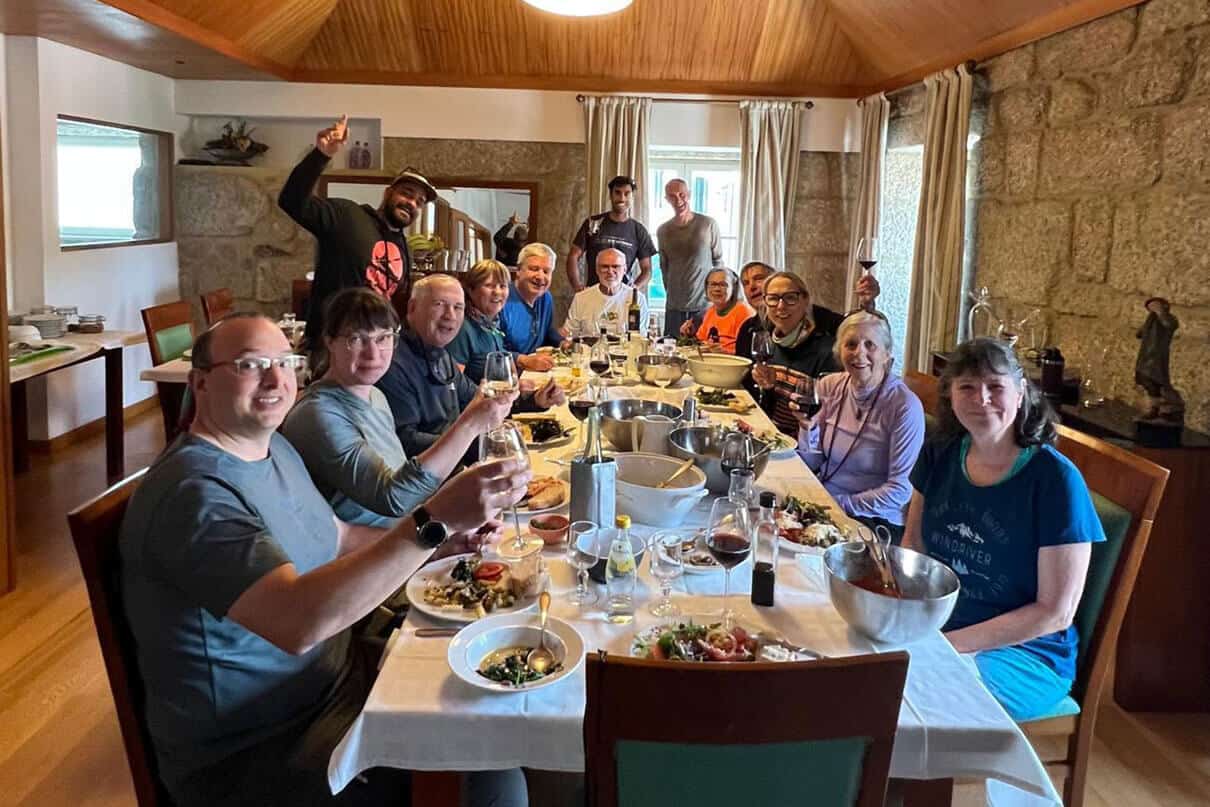 a group of people pose for a photo during a meal at a restaurant in Portugal