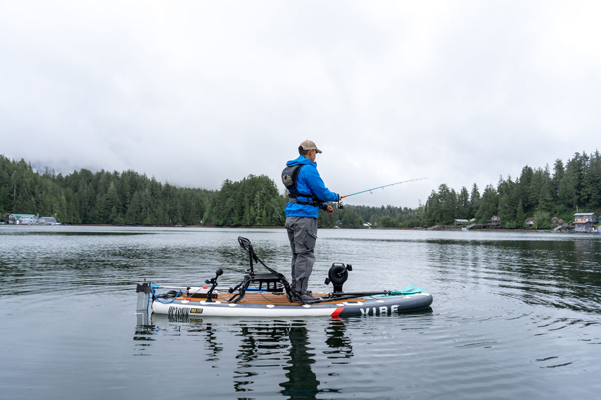 person stands and fishes from a hybrid SUP-kayak outfitted with Bixpy motor