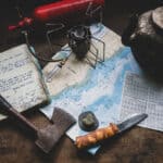 The Perils Of Plan Continuation Bias a map and various backcountry implements lay on a table