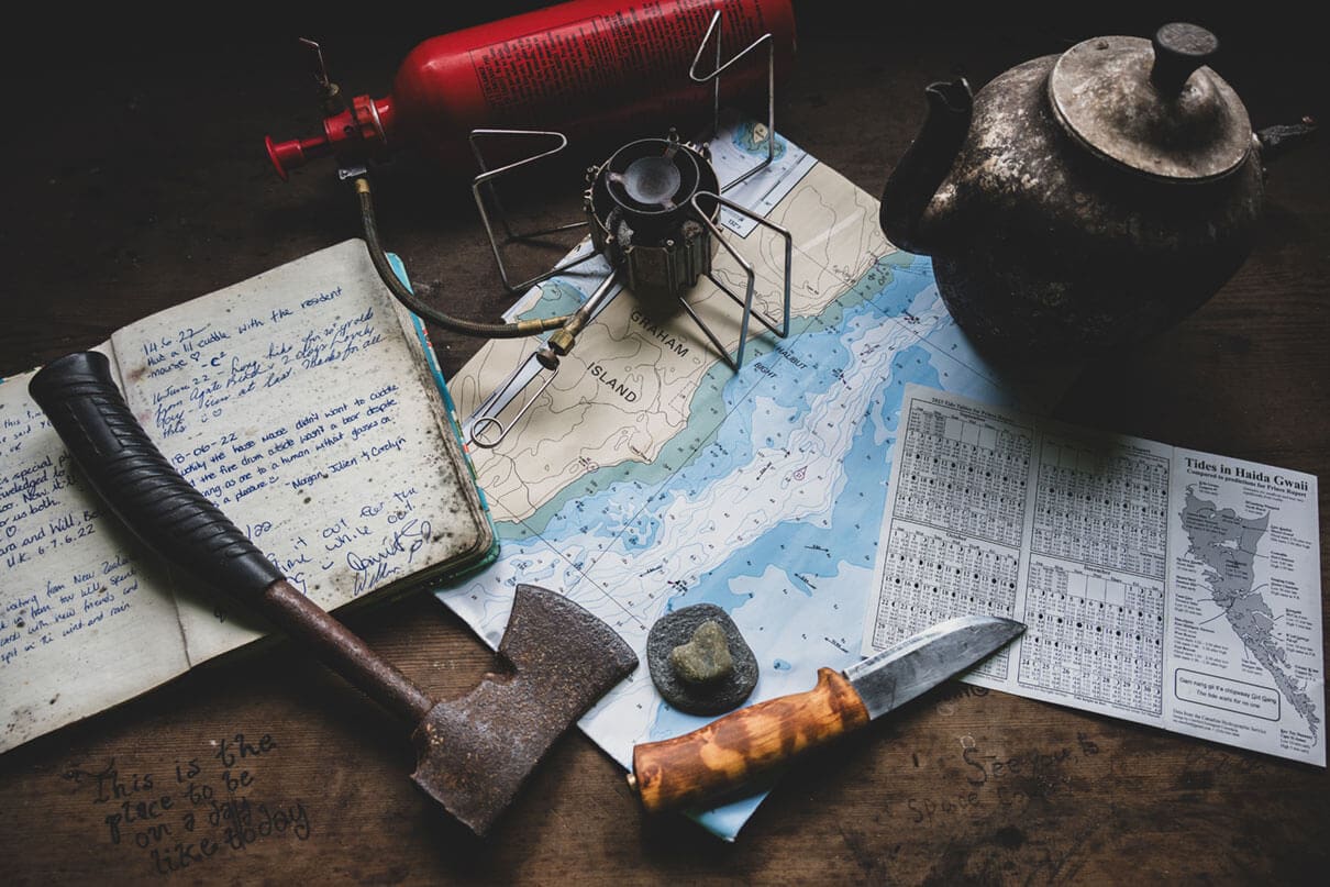 a map and various backcountry implements lay on a table