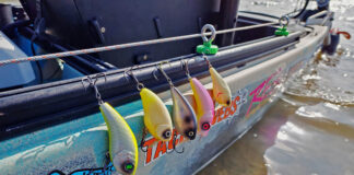 Wake Baits Go Saltwater Fishing a selection of wake baits are rigged to the side of a kayak before saltwater fishing
