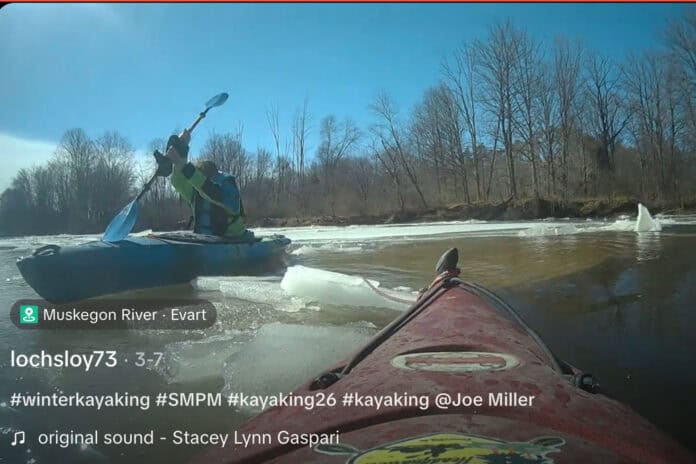 Image of a kayaker recovering another kayak on the Muskegon River in Michigan
