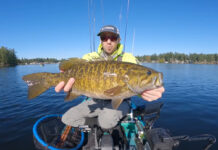 Kayak Angler Scores Massive Smallmouth On “Lake Of Giants” (Video) A kayak fisherman holds a massive bass up to the camera