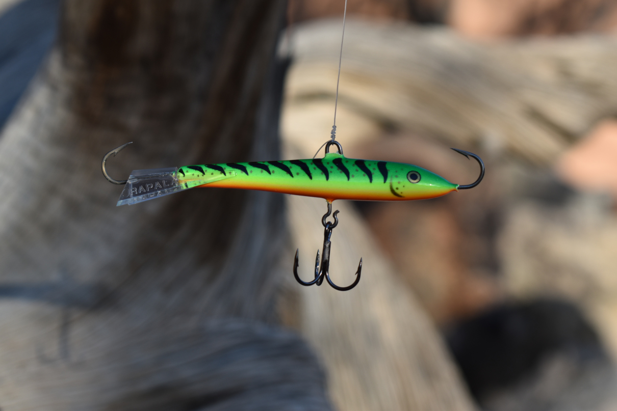 Rapala Jigging Rap with treble hook, dangling by fishing line.
