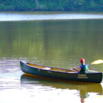Sage Advice From A Kayak Fishing Guru boy paddles a canoe on flatwater