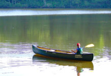 Sage Advice From A Kayak Fishing Guru boy paddles a canoe on flatwater