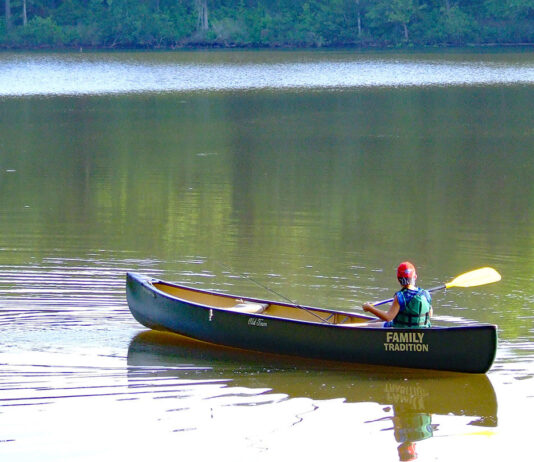 Sage Advice From A Kayak Fishing Guru boy paddles a canoe on flatwater