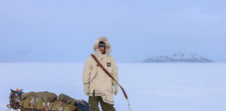 Inside Justin Barbour’s 4,000KM Journey Across The Hardest Route You’ve Never Heard Of Justin Barbour stands in snowshoes and parka with his loaded sled in the tundra