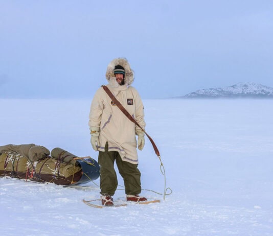 Inside Justin Barbour’s 4,000KM Journey Across The Hardest Route You’ve Never Heard Of Justin Barbour stands in snowshoes and parka with his loaded sled in the tundra