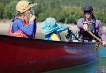 The Next Adventure Mom and two kids paddling in red canoe