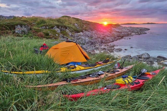 sunset view of a campsite with Nordkapp expedition kayaks during the anniversary trip